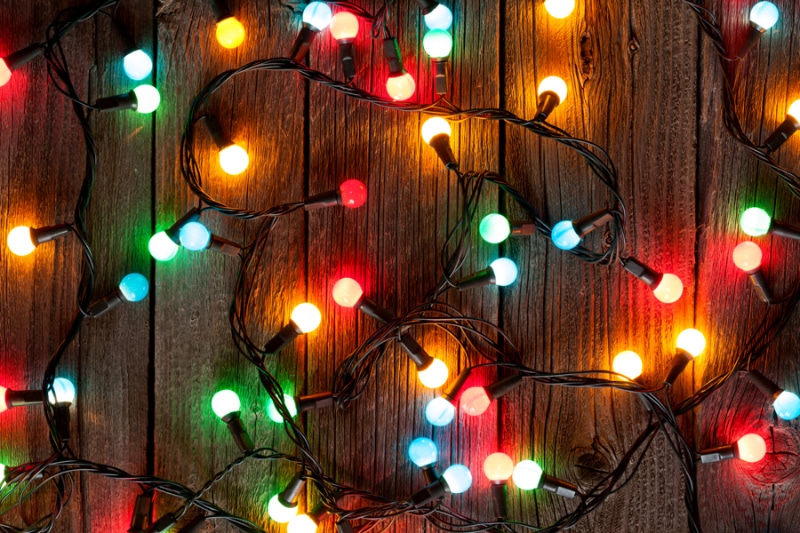 Holiday Safety Tips - Christmas colorful lights on wooden table.